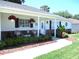 Charming single story home with a inviting front porch, hanging flower baskets, and lush landscaping at 13762 Sw 112Th Ter, Dunnellon, FL 34432