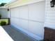 Exterior view of garage with newly installed white garage door with matching trim and brick accents at 13762 Sw 112Th Ter, Dunnellon, FL 34432