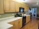 Functional kitchen with light wood cabinets and black appliances at 13762 Sw 112Th Ter, Dunnellon, FL 34432