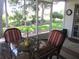 Relax on the screened porch with views of the garden, plants, flowers, and lush green landscaping at 13762 Sw 112Th Ter, Dunnellon, FL 34432