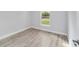 Bright bedroom featuring neutral paint, new wood-look floors, and natural light from a window at 13793 Sw 100 Ln, Dunnellon, FL 34432