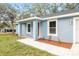 Quaint single-story home with light blue exterior, white trim, and welcoming front porch at 13793 Sw 100 Ln, Dunnellon, FL 34432