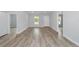 Bright living room featuring modern gray walls, light-colored wood flooring, and a large window view at 13793 Sw 100 Ln, Dunnellon, FL 34432