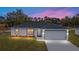Charming single-story home with a well-manicured lawn and a two-car garage against a lovely sunset backdrop at 15155 Sw 30 St, Ocala, FL 34481
