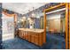 Retro bathroom boasts a long dual sink vanity, blue carpet, and floral wallpaper connecting to a dressing area with a lounger at 2416 Se 15Th St, Ocala, FL 34471