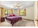 Cozy bedroom featuring an iron bed frame, neutral carpet and two windows at 2416 Se 15Th St, Ocala, FL 34471