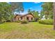 A single-story home with a mix of stone and wood facade, complimented by mature landscaping at 2416 Se 15Th St, Ocala, FL 34471