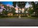 Single-story home with brick and wood facade, fronted by hedge landscaping and mature trees, at dusk at 2416 Se 15Th St, Ocala, FL 34471