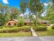 Charming single-story home with a manicured lawn, mature trees, and welcoming walkway at 2416 Se 15Th St, Ocala, FL 34471