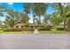 Charming single-story home featuring a brick facade, manicured landscaping, and mature shade trees at 2416 Se 15Th St, Ocala, FL 34471