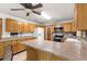 Well-lit kitchen featuring a breakfast bar and white appliances with wood cabinetry at 2416 Se 15Th St, Ocala, FL 34471