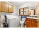 Laundry room with washer, dryer, toilet, and wooden cabinets at 2416 Se 15Th St, Ocala, FL 34471