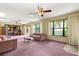 Bright living room featuring large windows, a ceiling fan, and comfortable seating at 2416 Se 15Th St, Ocala, FL 34471