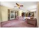 Spacious living area with ceiling fans, glass doors, and comfortable furniture arrangement at 2416 Se 15Th St, Ocala, FL 34471