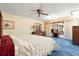 Spacious main bedroom with blue carpet, a ceiling fan, and sliding glass doors leading to an outdoor living space at 2416 Se 15Th St, Ocala, FL 34471