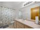 Bright bathroom featuring a shower with patterned curtain and a large mirror at 2521 Nw 45Th Pl, Ocala, FL 34475