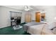 Bedroom featuring ceiling fan, adjacent desk, large bed and view into living room with fireplace at 2521 Nw 45Th Pl, Ocala, FL 34475