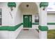 Inviting front entrance featuring a vibrant green door, textured columns, and a welcoming ambiance at 2521 Nw 45Th Pl, Ocala, FL 34475