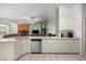 Open kitchen showcasing white cabinets, stainless steel appliances, and seamless flow to living area at 2521 Nw 45Th Pl, Ocala, FL 34475