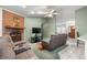 Relaxing living room with a brick fireplace, ceiling fan, and views to the kitchen area at 2521 Nw 45Th Pl, Ocala, FL 34475