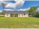 Lush backyard and home exterior featuring manicured lawn and a covered patio area at 2525 Sw 7Th Ave, Ocala, FL 34471