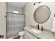 Bathroom featuring modern vanity with granite countertop, stylish mirror, and shower with tile surround at 2525 Sw 7Th Ave, Ocala, FL 34471