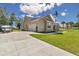 Wide driveway leading to a two-car garage with a lush lawn and blue skies above at 2525 Sw 7Th Ave, Ocala, FL 34471