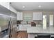 Well-lit kitchen with white cabinets, granite countertops, stainless steel appliances, and wood-look tile flooring at 2525 Sw 7Th Ave, Ocala, FL 34471