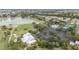 Aerial view showcases the golf course, lake, pool and clubhouse amidst a charming neighborhood in a desirable location at 2608 Casso Ct, The Villages, FL 32162