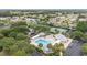 Aerial shot showcases a community pool, tennis courts, and lush landscaping amidst a charming neighborhood at 2608 Casso Ct, The Villages, FL 32162