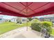 Enjoy outdoor living under the red awning of this home's patio and beautifully landscaped backyard at 2608 Casso Ct, The Villages, FL 32162
