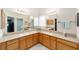 This spacious bathroom features double sinks with a large mirror, wooden cabinets, and a walk-in shower at 2608 Casso Ct, The Villages, FL 32162
