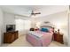Cozy bedroom with soft carpet, a ceiling fan, and a comfortable bed with accent pillows at 2608 Casso Ct, The Villages, FL 32162