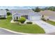 Charming single-story home with a well-manicured lawn, beautiful landscaping, and a two-car garage at 2608 Casso Ct, The Villages, FL 32162