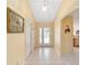 Bright foyer with tile flooring, arched doorway, and views into living spaces with neutral paint at 2608 Casso Ct, The Villages, FL 32162