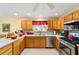 Bright kitchen features stainless steel appliances, light wood cabinets, and neutral countertops at 2608 Casso Ct, The Villages, FL 32162