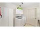 This laundry room features a white washer and dryer, and white storage cabinets for household necessities at 2608 Casso Ct, The Villages, FL 32162