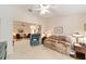 Cozy living room with neutral walls, carpet, ceiling fan, and comfortable seating arrangement at 2608 Casso Ct, The Villages, FL 32162