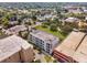 Aerial view of a modern condo building with parking, surrounded by mature trees and neighborhood houses at 302 Se Broadway St # 240, Ocala, FL 34471