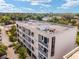 Aerial view of a modern condo building with private balconies, surrounded by mature trees and a rooftop at 302 Se Broadway St # 240, Ocala, FL 34471