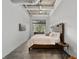 Modern bedroom with concrete floors, a comfortable bed, and a bright window with a peaceful view at 302 Se Broadway St # 240, Ocala, FL 34471