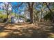 Large backyard with mature trees and sheds, offering ample space and storage opportunities at 3299 County Road 521, Wildwood, FL 34785