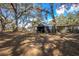 Large backyard featuring mature trees, outbuildings, and plenty of space for outdoor activities at 3299 County Road 521, Wildwood, FL 34785