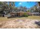 View of the backyard and back of the property, including screened porch and additional structures at 3299 County Road 521, Wildwood, FL 34785