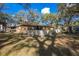 Wide backyard view of a home featuring a white picket fence, mature trees, and large lawn at 3299 County Road 521, Wildwood, FL 34785