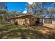 Exterior view of the home with a spacious backyard and screened porch at 3299 County Road 521, Wildwood, FL 34785