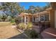 Charming single-story home with well-kept landscaping and a cozy, covered patio area with black metal fencing at 3299 County Road 521, Wildwood, FL 34785