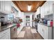 Modern kitchen with stainless steel appliances, granite counters, white cabinets and backsplash, and wood-look vinyl floors at 3299 County Road 521, Wildwood, FL 34785