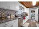Well-lit kitchen showcasing stainless steel appliances, granite countertops, white cabinets, and decorative backsplash tile at 3299 County Road 521, Wildwood, FL 34785