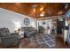 Inviting living room boasts a wood-paneled ceiling, comfortable seating, and a decorative rug over wood floors at 3299 County Road 521, Wildwood, FL 34785